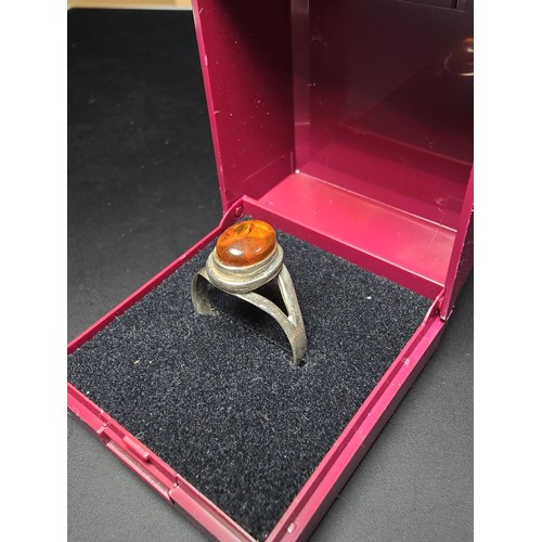 210 - An attractive 925 silver dress ring inset with a large natural Baltic amber cabochon stone. In excel... 