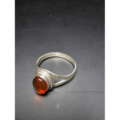 210 - An attractive 925 silver dress ring inset with a large natural Baltic amber cabochon stone. In excel... 