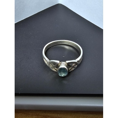 222 - A 925 silver ring with the Rennie Mackintosh design inset with a faceted blue CZ crystal stone, size... 