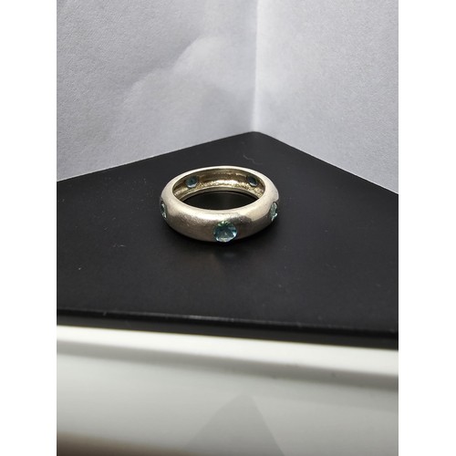 223 - A chunky 925 silver ring inset with faceted light blue crystal CZ stones all the way around. Size J,... 