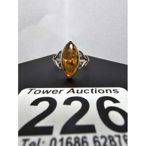 226 - A pretty 925 silver dress ring inset with a large natural Baltic amber stone, size O.5, in good clea... 