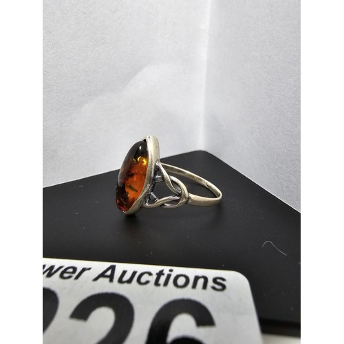 226 - A pretty 925 silver dress ring inset with a large natural Baltic amber stone, size O.5, in good clea... 