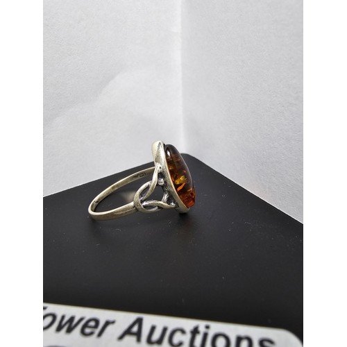 226 - A pretty 925 silver dress ring inset with a large natural Baltic amber stone, size O.5, in good clea... 