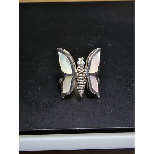 228 - A very pretty 925 sterling silver butterfly ring featuring a large butterfly design inset with mothe... 