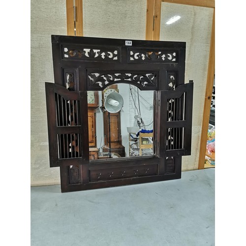 144 - Large impressive rosewood Indonesian shuttered mirror with carving to the edges, doors open to revea... 