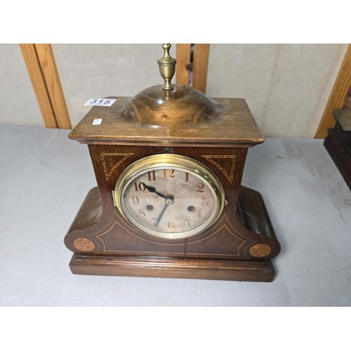 315 - An attractive mahogany vintage mantel clock featuring an unusual dome wooden top and inlay decoratio... 