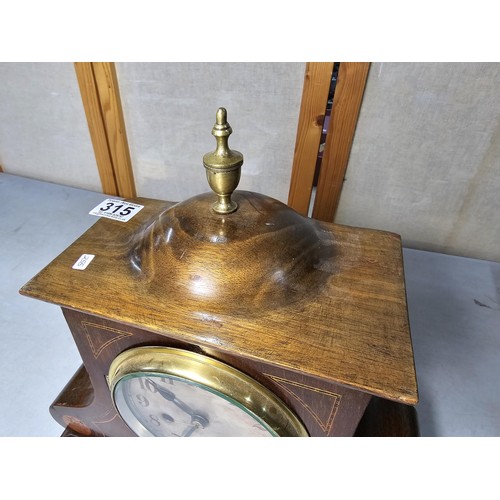 315 - An attractive mahogany vintage mantel clock featuring an unusual dome wooden top and inlay decoratio... 