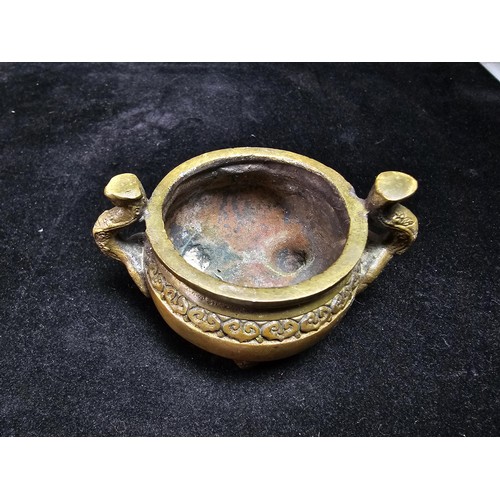 318 - An antique Chinese bronze incense burner having an ornate design with 2 handles either side and a fl... 