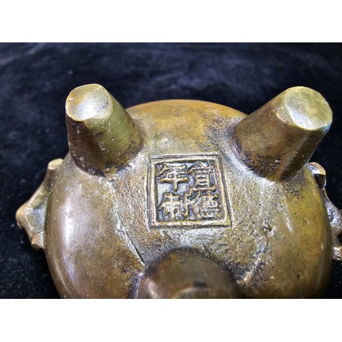 318 - An antique Chinese bronze incense burner having an ornate design with 2 handles either side and a fl... 