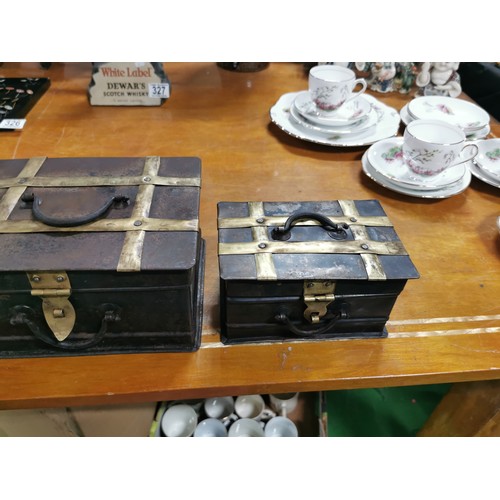 327 - A quantity of 3x arts & crafts graduated metal and brass banded storage trunks with cast iron handle... 