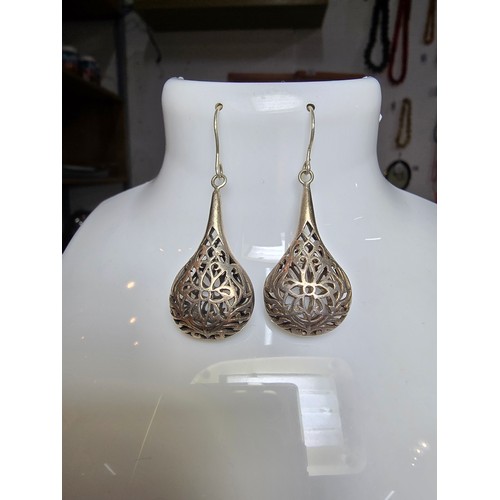 233 - A pair of large and ornate 925 silver drop earrings with an intricate pierced design, the earrings a... 