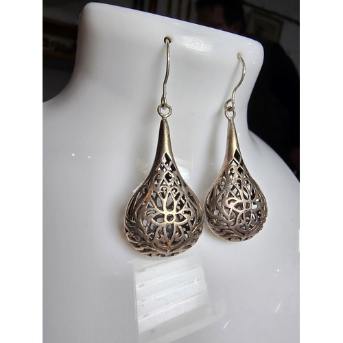 233 - A pair of large and ornate 925 silver drop earrings with an intricate pierced design, the earrings a... 