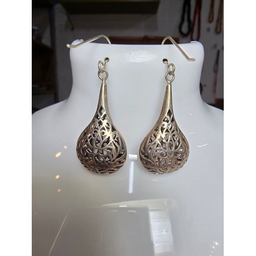 233 - A pair of large and ornate 925 silver drop earrings with an intricate pierced design, the earrings a... 