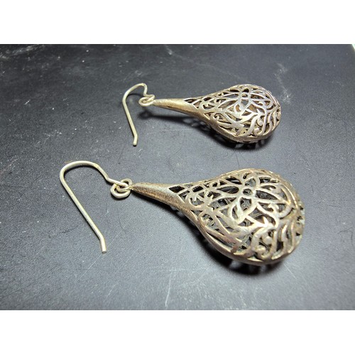 233 - A pair of large and ornate 925 silver drop earrings with an intricate pierced design, the earrings a... 