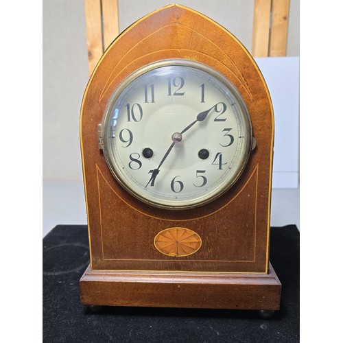 325 - An attractive antique lancet shaped mahogany mantel clock with string inlay and inlay panel to the f... 