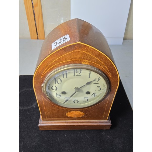 325 - An attractive antique lancet shaped mahogany mantel clock with string inlay and inlay panel to the f... 