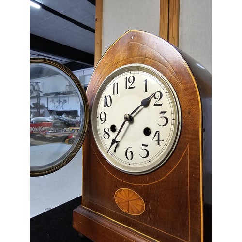 325 - An attractive antique lancet shaped mahogany mantel clock with string inlay and inlay panel to the f... 