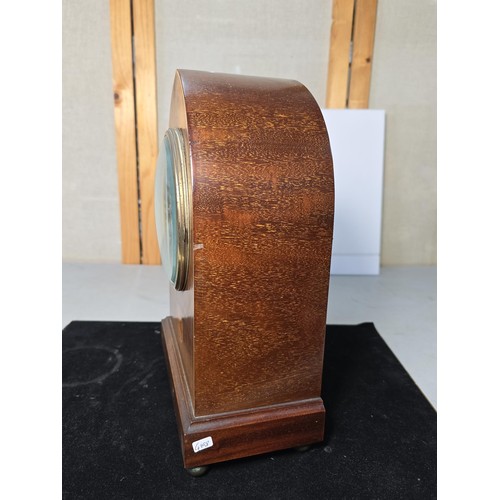 325 - An attractive antique lancet shaped mahogany mantel clock with string inlay and inlay panel to the f... 