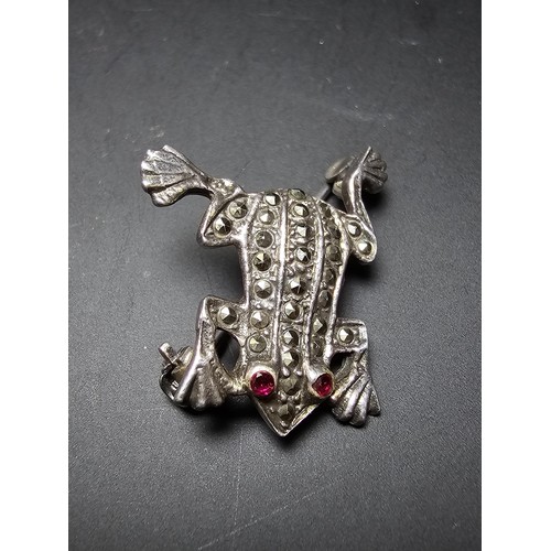 241 - A pretty vintage 925 silver brooch in the form of a frog inset  with marcasite stones having red spi... 