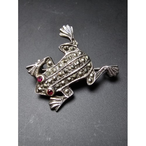 241 - A pretty vintage 925 silver brooch in the form of a frog inset  with marcasite stones having red spi... 