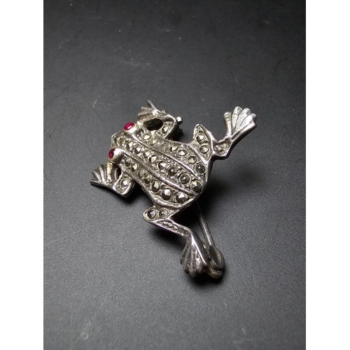 241 - A pretty vintage 925 silver brooch in the form of a frog inset  with marcasite stones having red spi... 