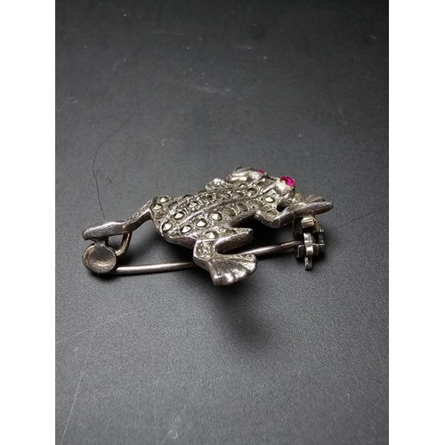 241 - A pretty vintage 925 silver brooch in the form of a frog inset  with marcasite stones having red spi... 