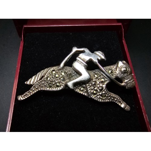 242 - A pretty vintage 925 silver jockey on racing horse formed brooch inset with marcasite stones, in exc... 