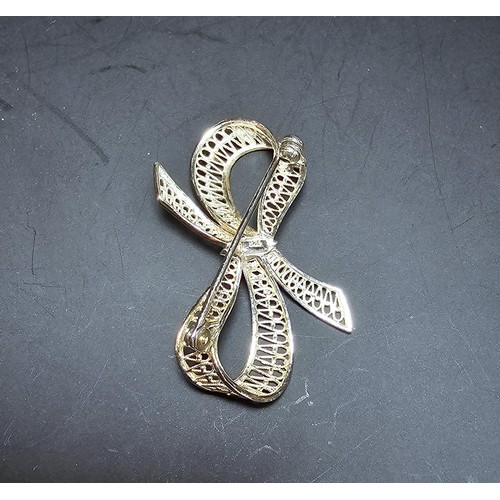 244 - A new and unused 925 silver bow formed brooch with an intricate pierced work design. Has a length of... 