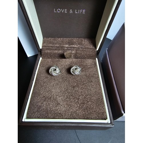 250 - A boxed pair of hallmarked 9ct white gold knot formed stud earrings along with a boxed 925 silver ri... 