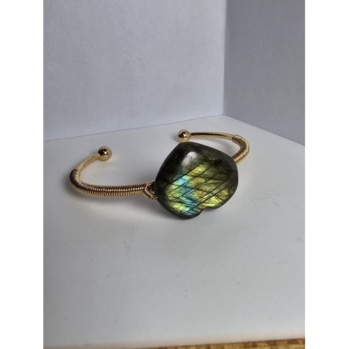 252 - A new and unused gold plated bangle inset with a heart shaped labradorite stone having excellent fla... 