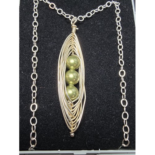 262 - An attractive as new unused handmade pendant with silver wire work inset with 3 green faux pearls, a... 