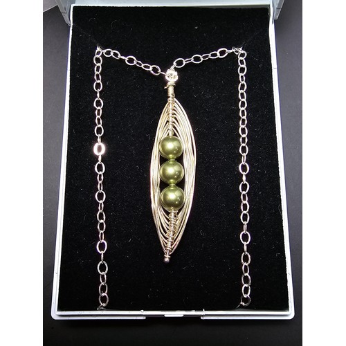 262 - An attractive as new unused handmade pendant with silver wire work inset with 3 green faux pearls, a... 