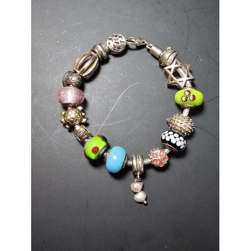 272 - A heavy comprehensive 925 sterling silver charm bracelet containing 16 sterling silver charms which ... 