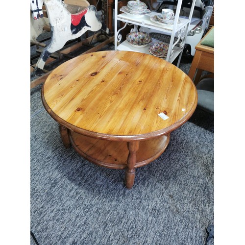 528 - Pine Stained Round Coffee Table. In good overall condition with a shelf on the base. Measures 44cm i... 