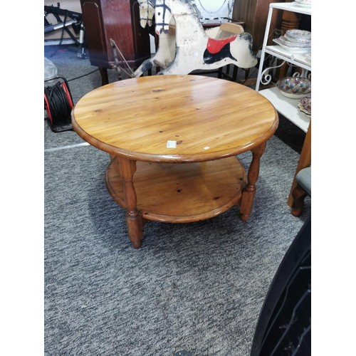 528 - Pine Stained Round Coffee Table. In good overall condition with a shelf on the base. Measures 44cm i... 