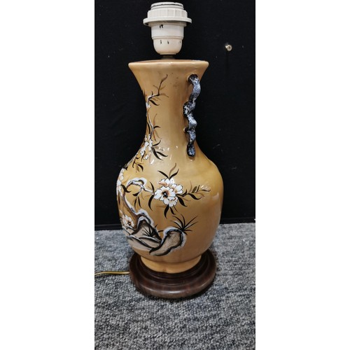 72 - An Indian tree ceramic lamp along with a beige coloured lamp on wooden base. Largest lamp measures 3... 
