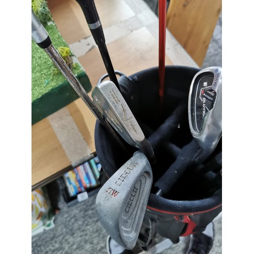 7 - A golf bag containing a quantity of gold clubs to include a 5, a 6, 2x 7's an 8, 2 sandwich and 1 pi... 
