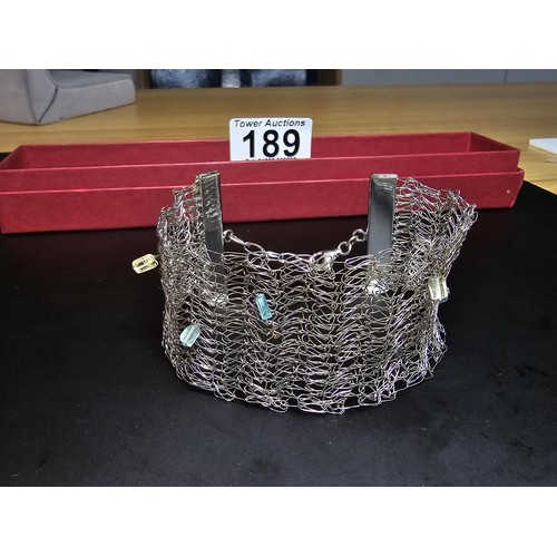 189 - An unusual 925 silver wide formed bracelet featuring an intricate wire-work design featuring crystal... 