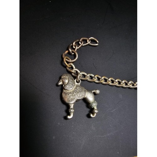 195 - An unusual silver plated charm bracelet featuring 4x well cast silver plated dog charms, each dog ch... 