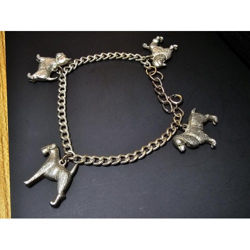 195 - An unusual silver plated charm bracelet featuring 4x well cast silver plated dog charms, each dog ch... 