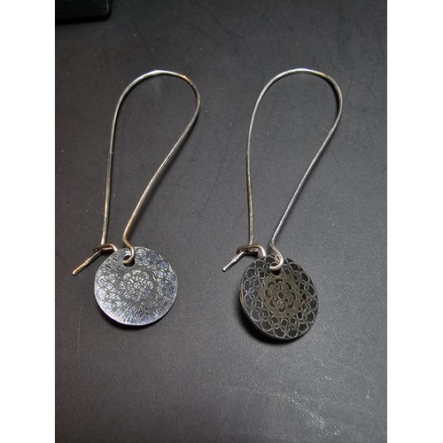 197 - A pair of new and unused 925 silver long drop earrings with an engraved disk drop by JF. Earrings ha... 