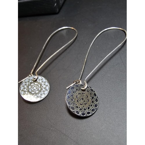 197 - A pair of new and unused 925 silver long drop earrings with an engraved disk drop by JF. Earrings ha... 