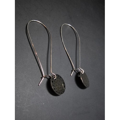 197 - A pair of new and unused 925 silver long drop earrings with an engraved disk drop by JF. Earrings ha... 