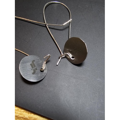 197 - A pair of new and unused 925 silver long drop earrings with an engraved disk drop by JF. Earrings ha... 