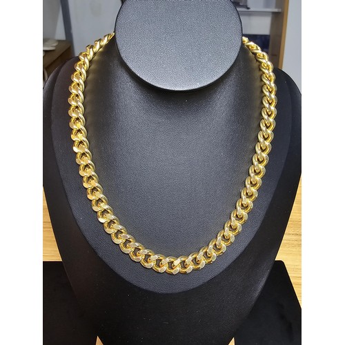 202 - A large unused heavy duty gold plated curb link neck chain with a bar and T clasp along with an 18ct... 