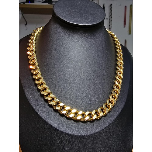 202 - A large unused heavy duty gold plated curb link neck chain with a bar and T clasp along with an 18ct... 