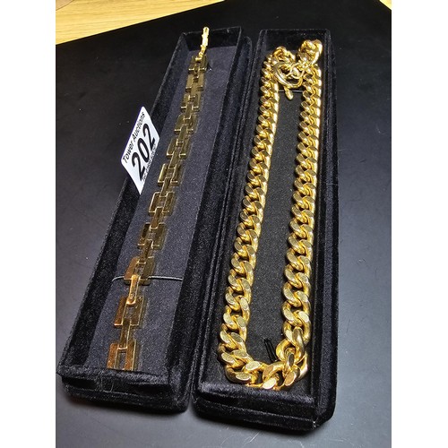 202 - A large unused heavy duty gold plated curb link neck chain with a bar and T clasp along with an 18ct... 