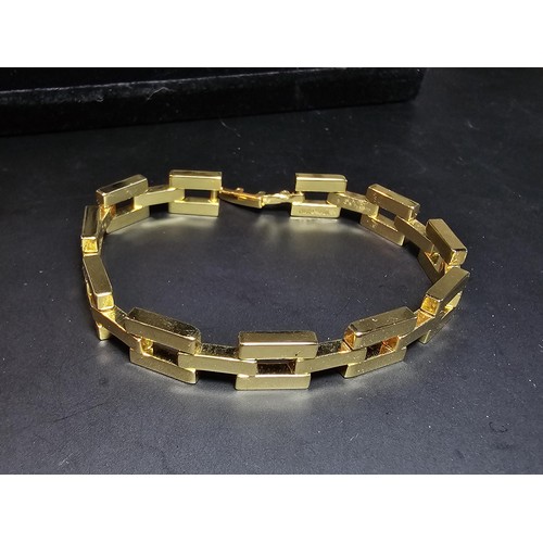 202 - A large unused heavy duty gold plated curb link neck chain with a bar and T clasp along with an 18ct... 