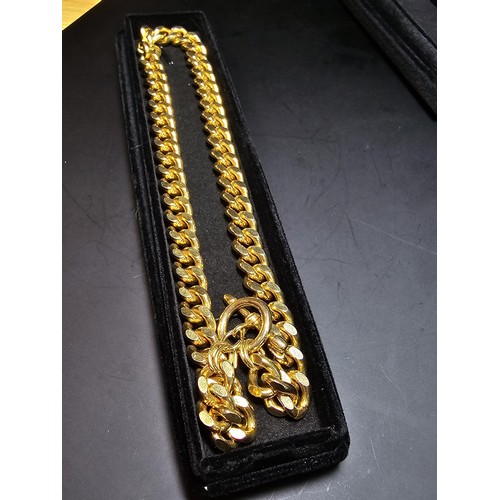 202 - A large unused heavy duty gold plated curb link neck chain with a bar and T clasp along with an 18ct... 