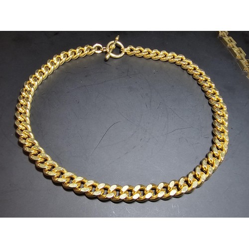 202 - A large unused heavy duty gold plated curb link neck chain with a bar and T clasp along with an 18ct... 